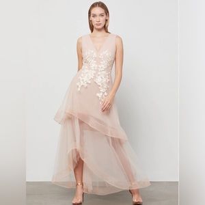 BCBG MAXAZRIA light blush asymmetrical gown with floral appliqués.